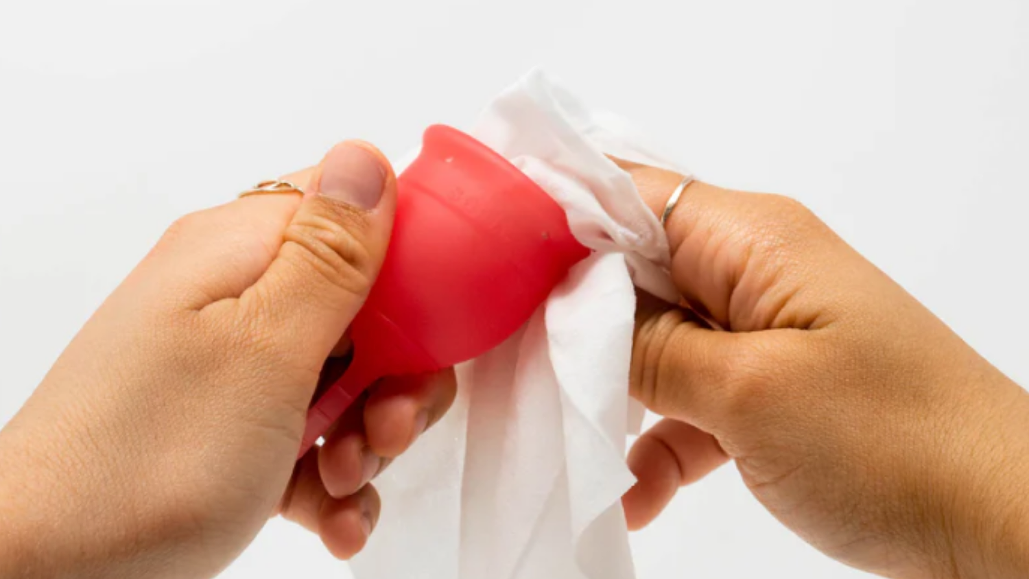 A Person Cleaning Their Menstrual Cup With Saalt Intimate Cleansing Wipes