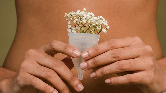 Person Holding A Menstrual Cup With Flowers In It