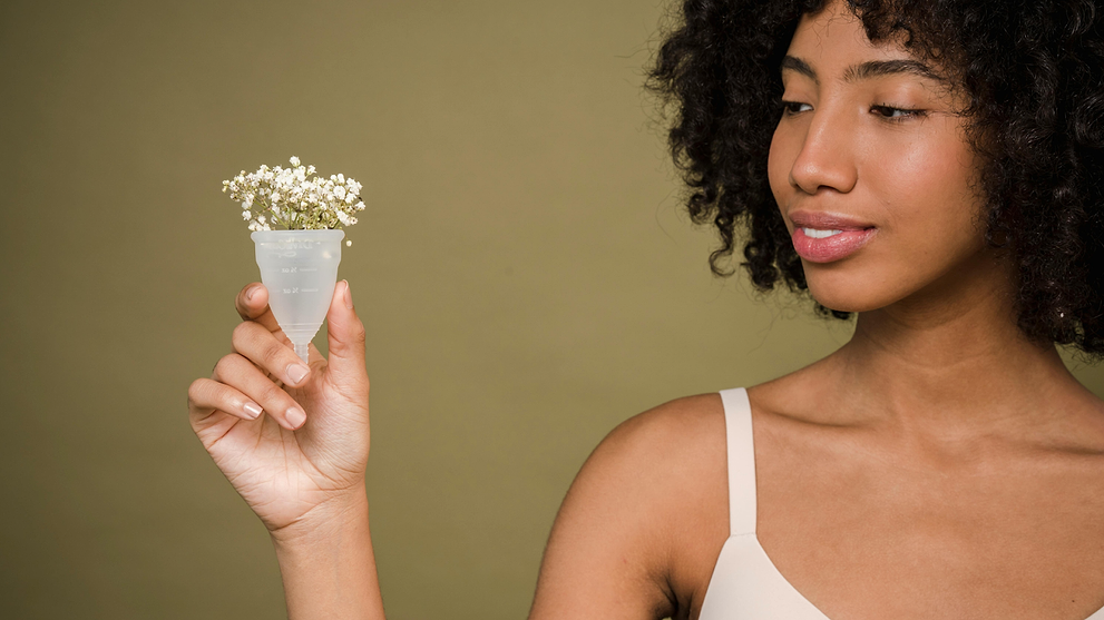 Woman Holding A Menstrual Cup With Flowers In It