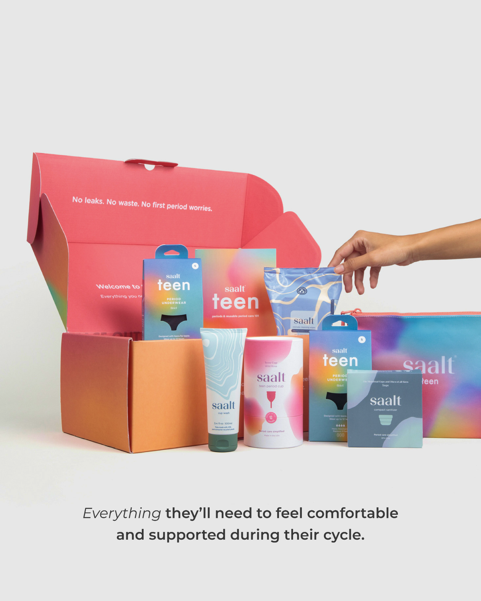 Colorful period product packaging with "saalt teen" branding in an open box. A hand reaches for a pouch of Saalt Wipes. Text inside box says, "No leaks. No waste. No first period worries."