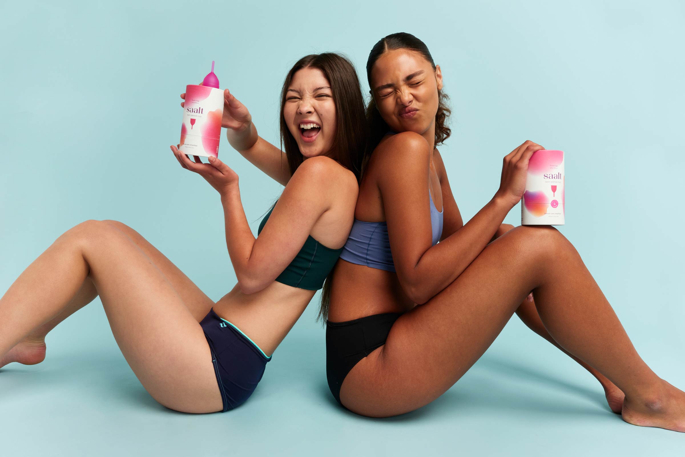 Two teen females holding the Saalt teen cup product
