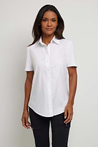 The Best Travel Top. Woman Showing the Front Profile of a Helia Top in White.