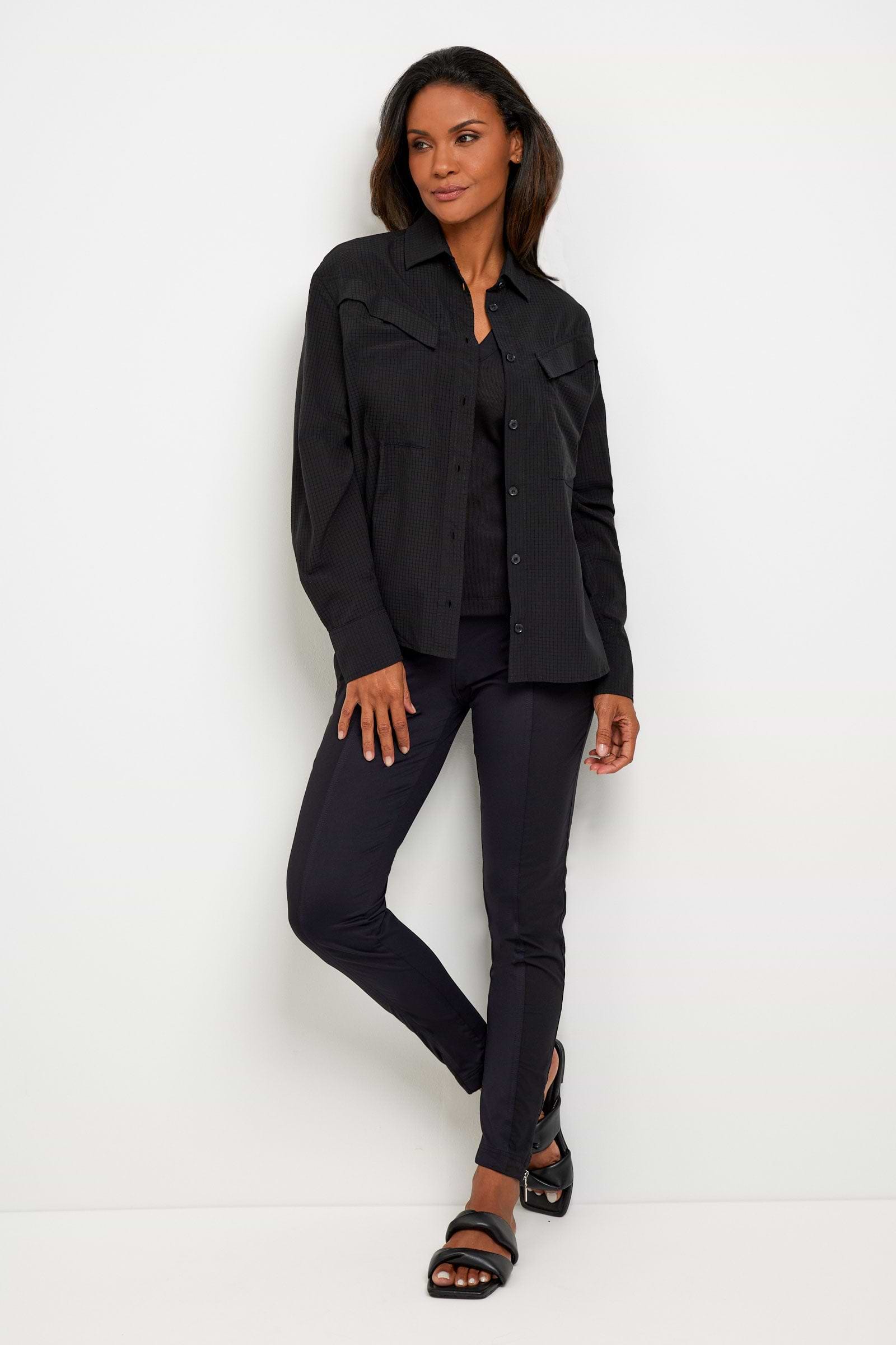 The Best Travel Top. Woman Showing the Front Profile of a Kieran Top in Black.