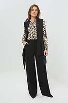Black vest worn open and untied, paired with a cheetah-print button-down shirt and slim black pants 