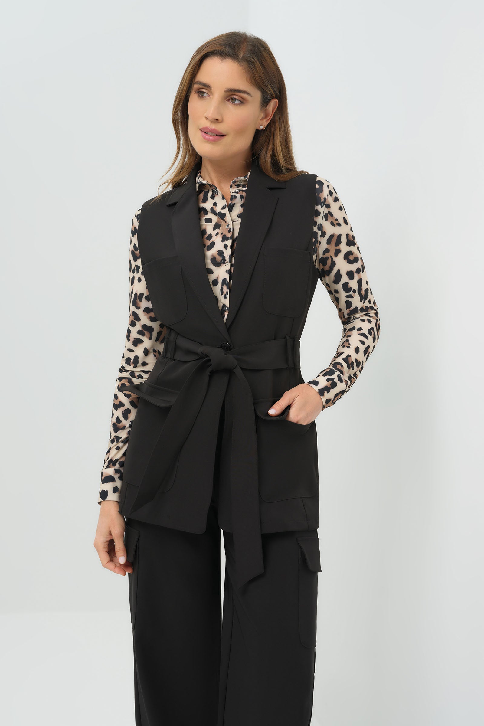 Black vest tied at the waist, paired with a cheetah-print button-down shirt and slim black pants 