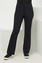 Front view of the Winny Black Pant by Anatomie, featuring a fitted waistband with a button closure, slim pockets, and a sleek, slightly flared leg design. The model is wearing casual white sneakers.