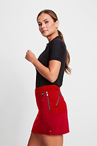 The Best Travel Skort. Woman Showing the Side Profile of a Suzzette Sport Luxe Skort in Atomic Red.