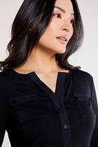 The Best Travel Shirt. Woman Showing the Front Buttons of a Calista Roll up Henley Top in Black