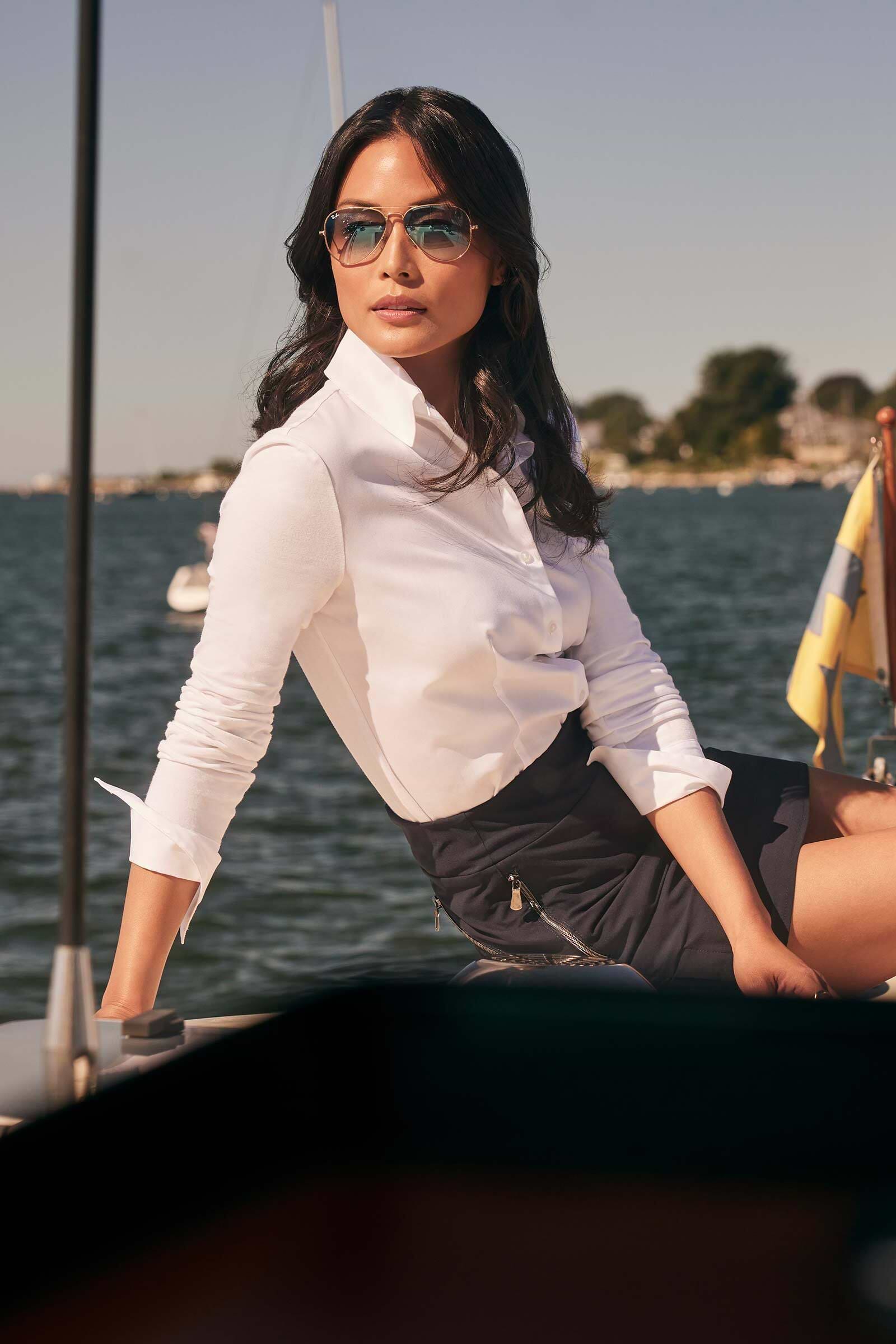 The Best Travel Button Down Poplin Shirt. Woman on a Yacht Showing the Side Profile of an Alida Button Down Poplin Shirt in White