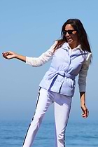 The Best Travel Vest. Lifestyle Image of a Woman Showing the Front Profile of an Ainslee Quilted Vest in Periwinkle