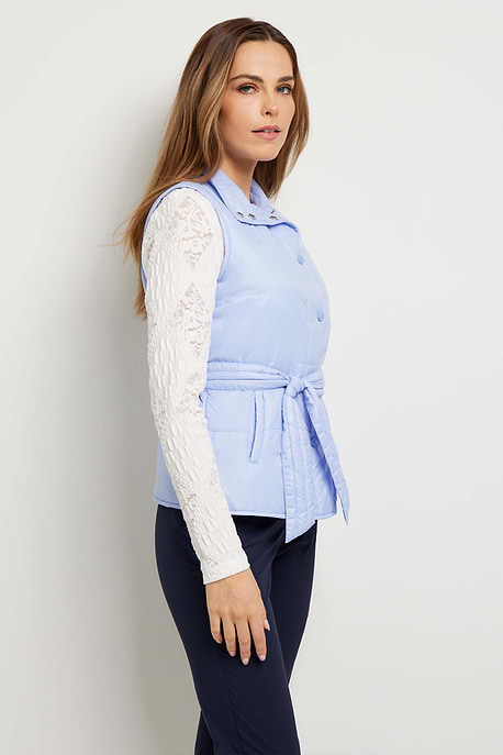 The Best Travel Vest. Woman Showing the Side Profile of an Ainslee Quilted Vest in Periwinkle