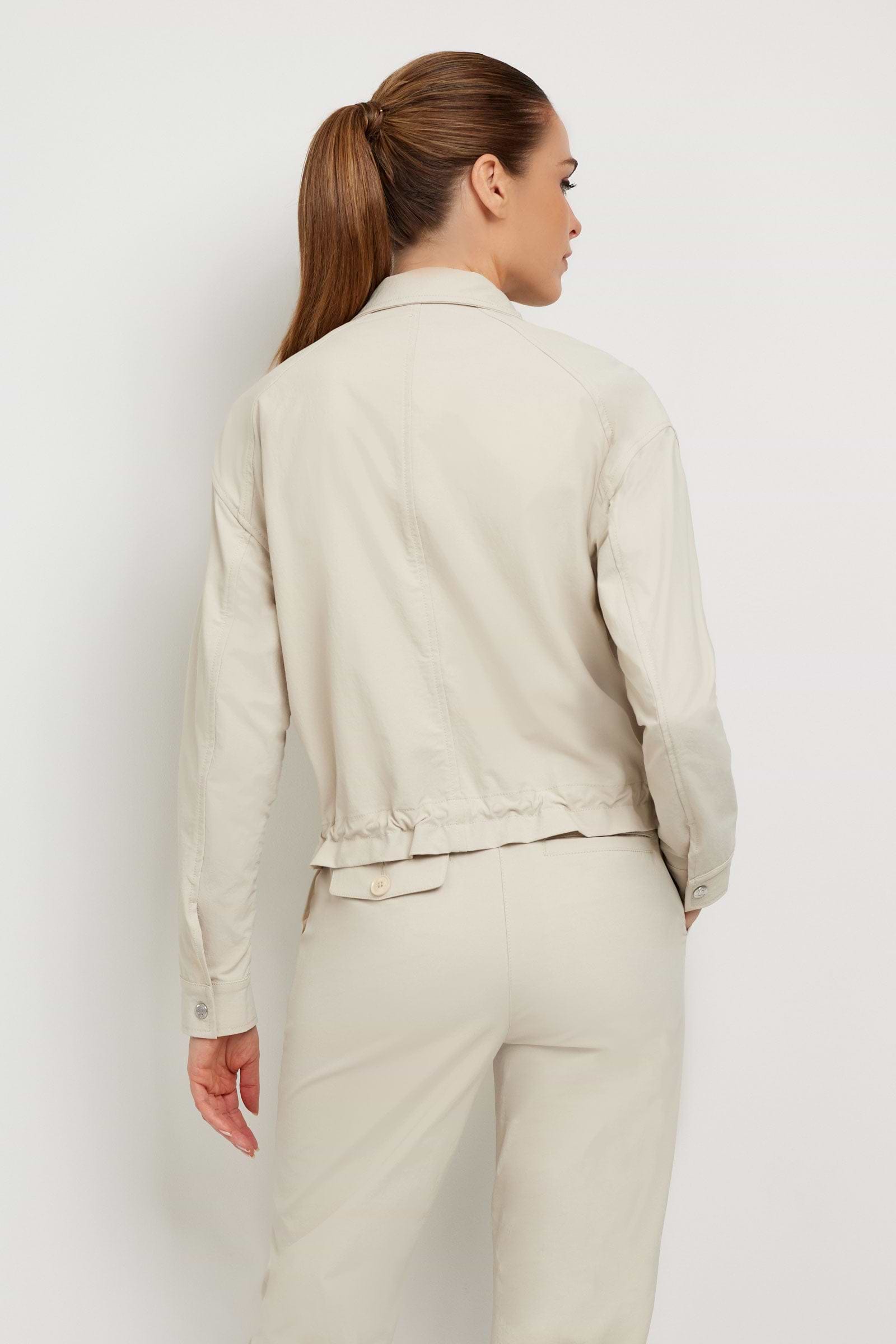 The Best Travel Jacket. Woman Showing the Back Profile of a Blaise Jacket in Champagne.