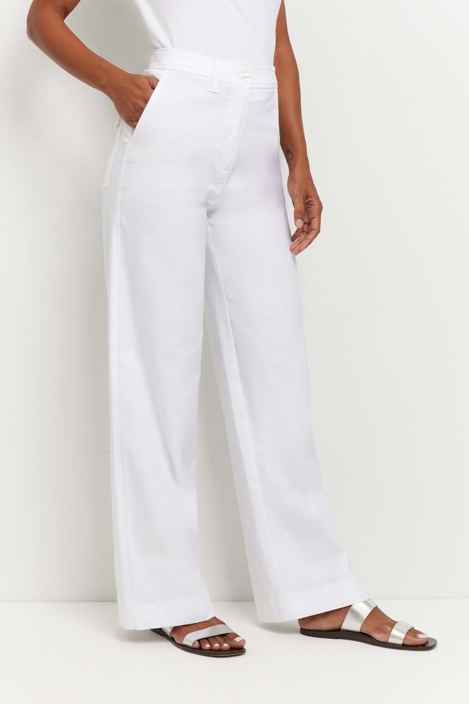 The Best Travel Pants. Woman Showing the Side of a Brooklyn Pant in White.