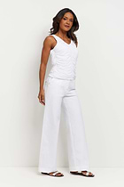 The Best Travel Pants. Woman Showing the Side Profile of a Brooklyn Pant in White.