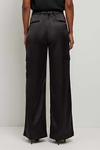 The Best Travel Pant. Back Profile of a Candela Satin Pant in Black.