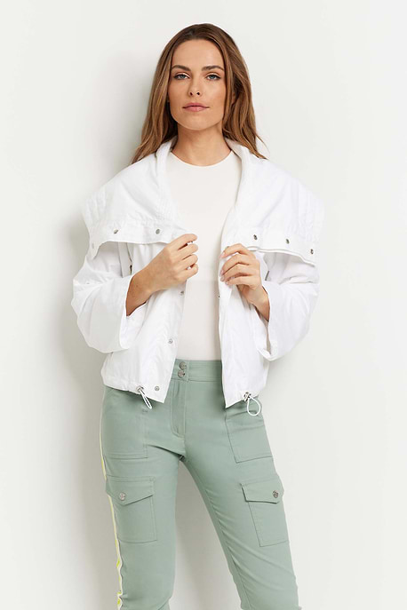 The Best Travel Jacket. Woman Showing the Front Profile of a Casey Windbreaker in White.