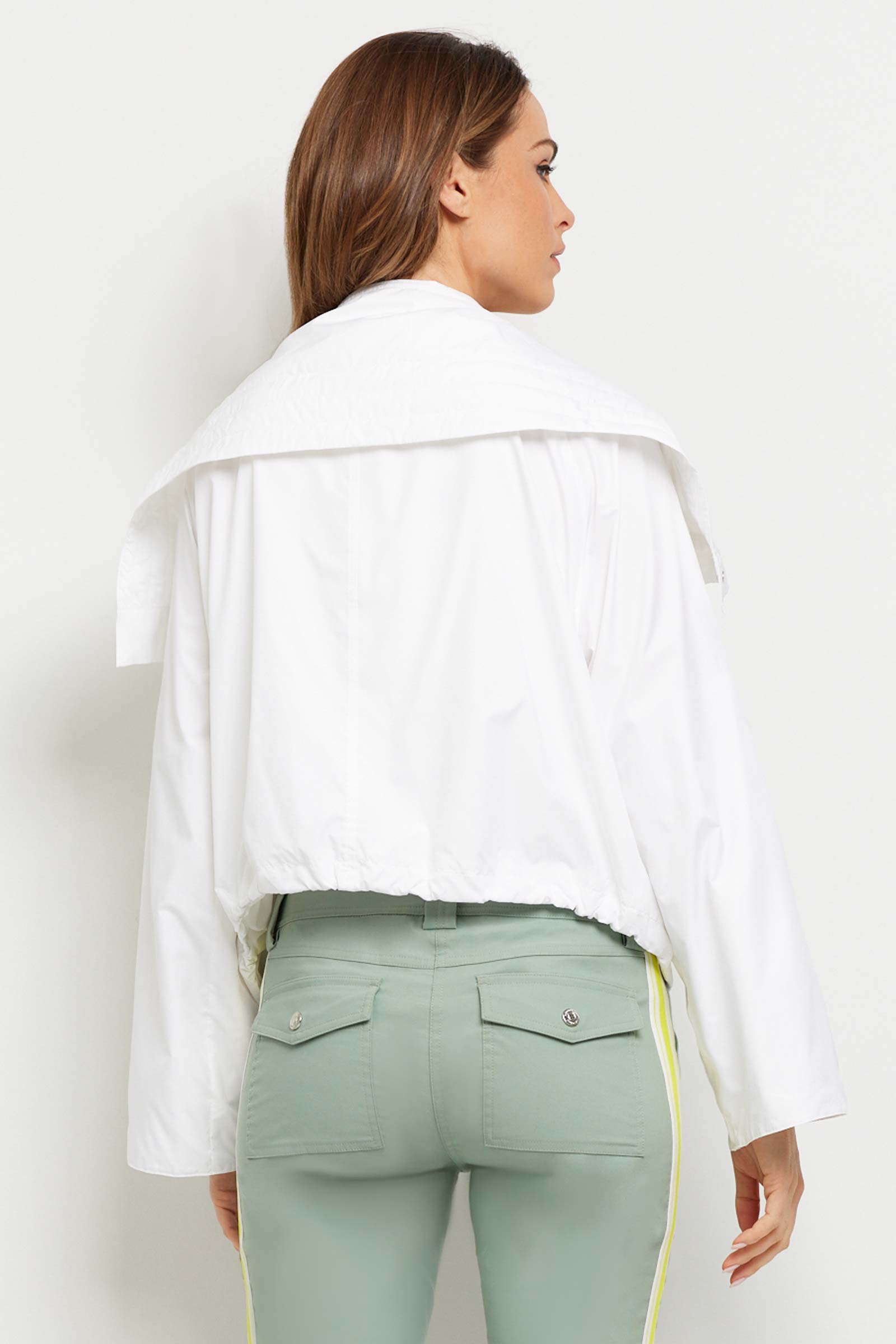 The Best Travel Jacket. Woman Showing the Back Profile of a Casey Windbreaker in White.