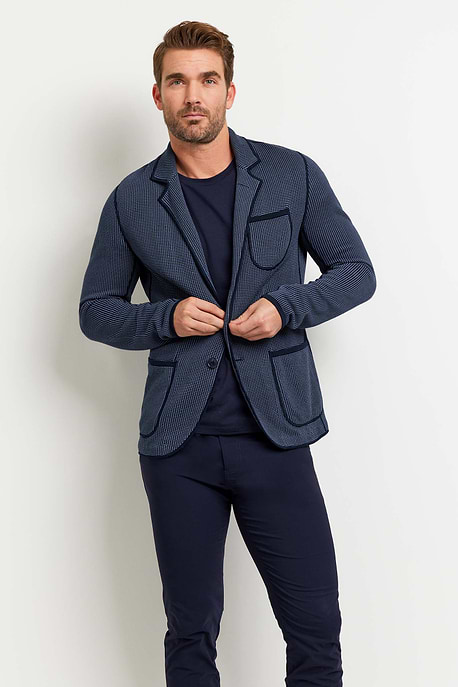 The Best Travel Jacket. Man Showing the Front Profile of a Men's Duncan Jacket in 2 Tone Blue.