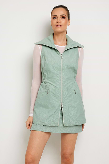The Best Travel Vest. Woman Showing the Front Profile of an Embossed Delaney Vest in Cheetah Sage.