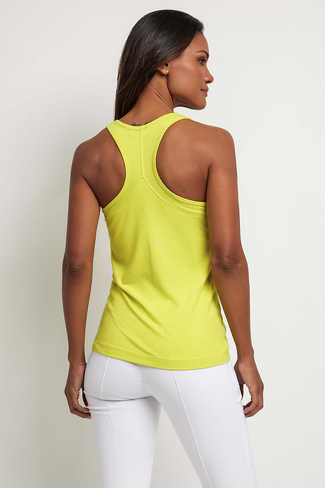 The Best Travel Tops. Woman Showing the Back Profile of an Emani Tank in Citrus Yellow.