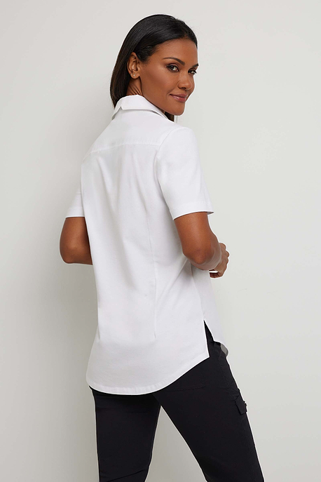 The Best Travel Top. Woman Showing the Back Profile of a Helia Top in White.