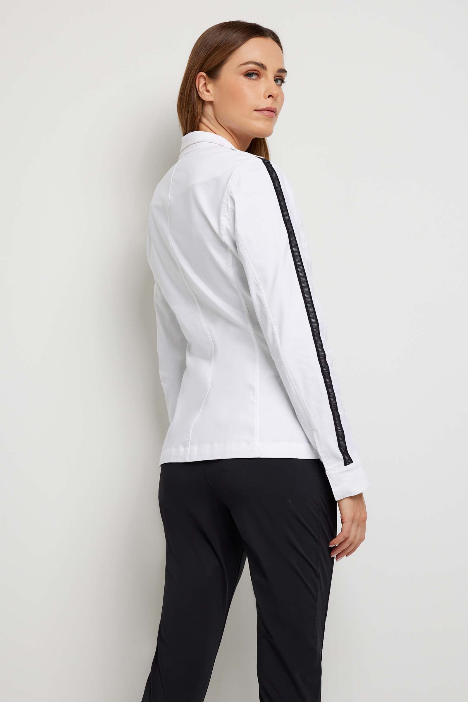 The Best Travel Jacket. Woman Showing the Back Profile of a Justine Jacket in White.