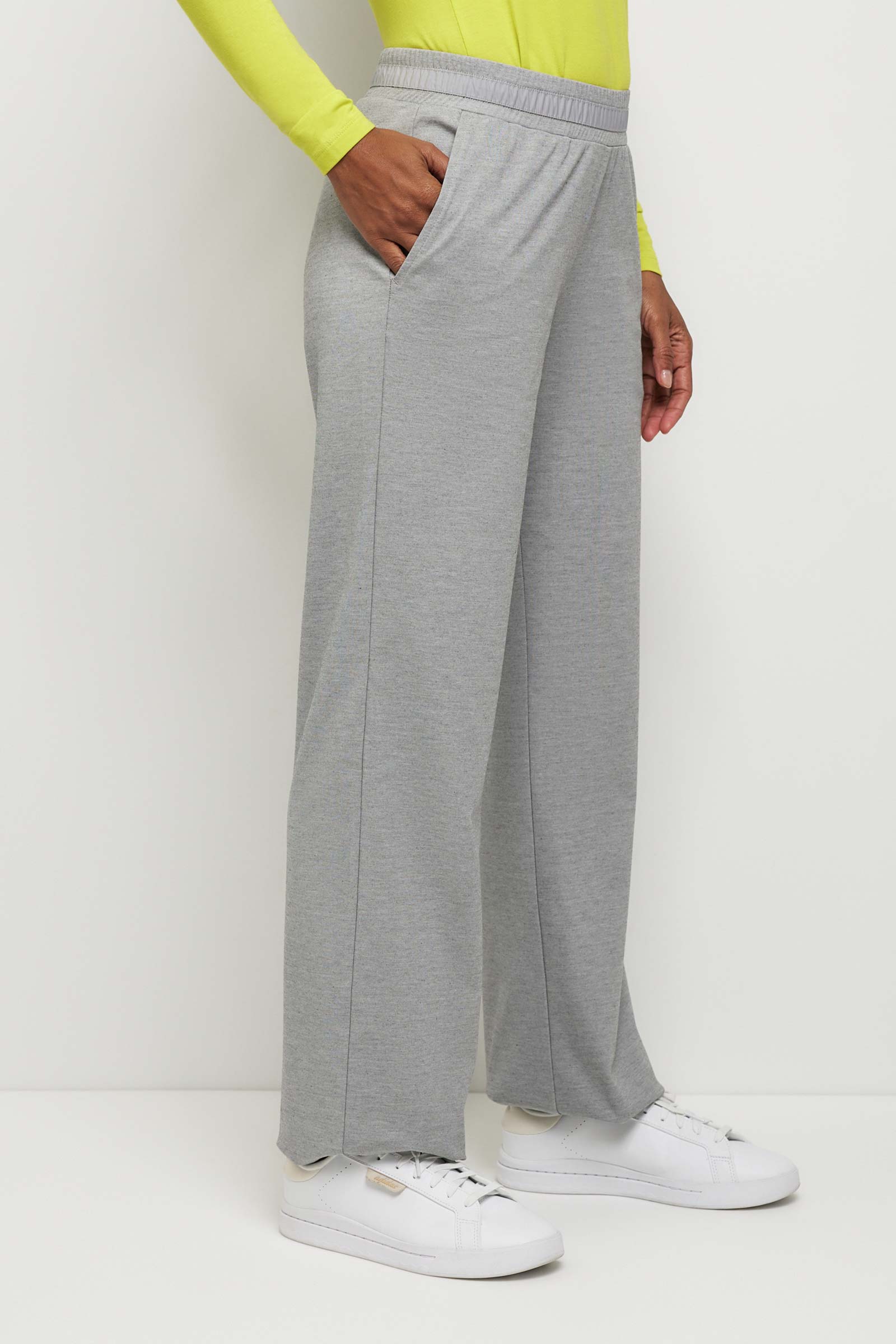 The Best Travel Pants. Woman Showing the Side Profile of a Kaia Pant in Light Heather Grey.