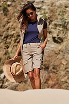 The Best Travel Shorts. Lifestyle Image of Woman Showing the Front Profile of an Apiedi Shorts in Khaki.