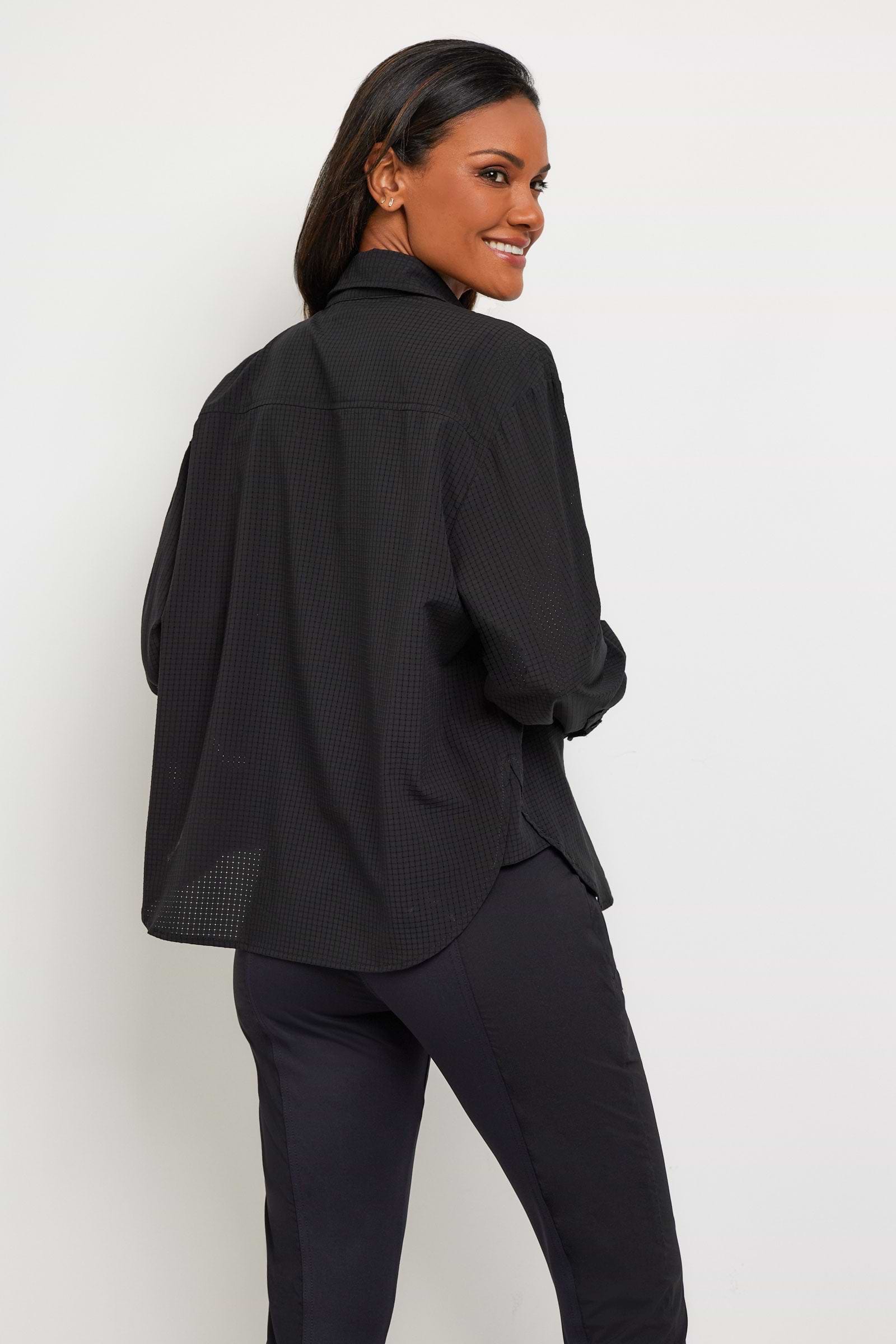 The Best Travel Top. Woman Showing the Back Profile of a Kieran Top in Black.