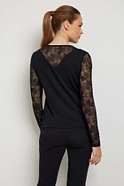 The Best Travel Top. Woman Showing the Back Profile of a Kim Camo Mesh Top in Black.