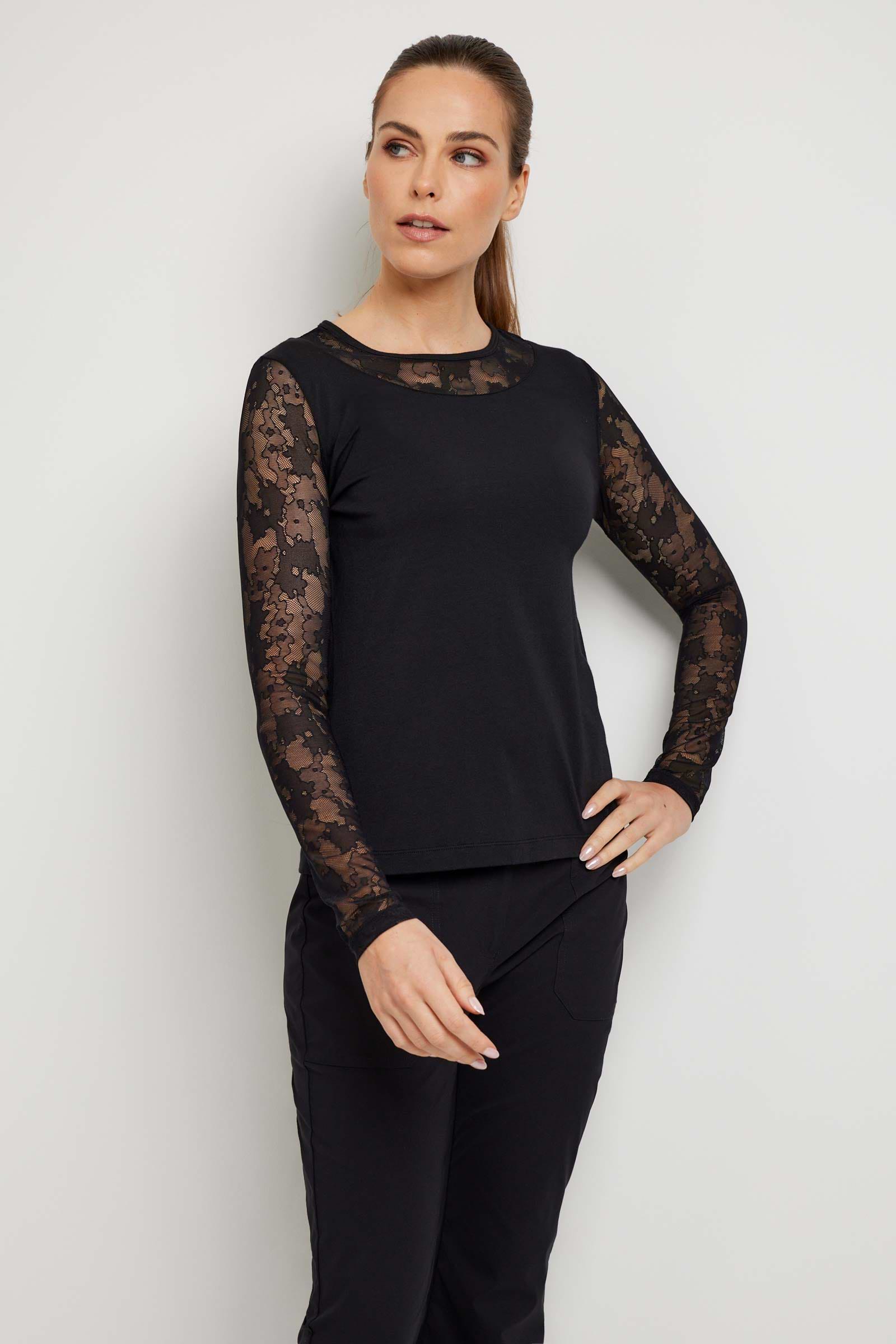 The Best Travel Top. Woman Showing the Front Profile of a Kim Camo Mesh Top in Black.