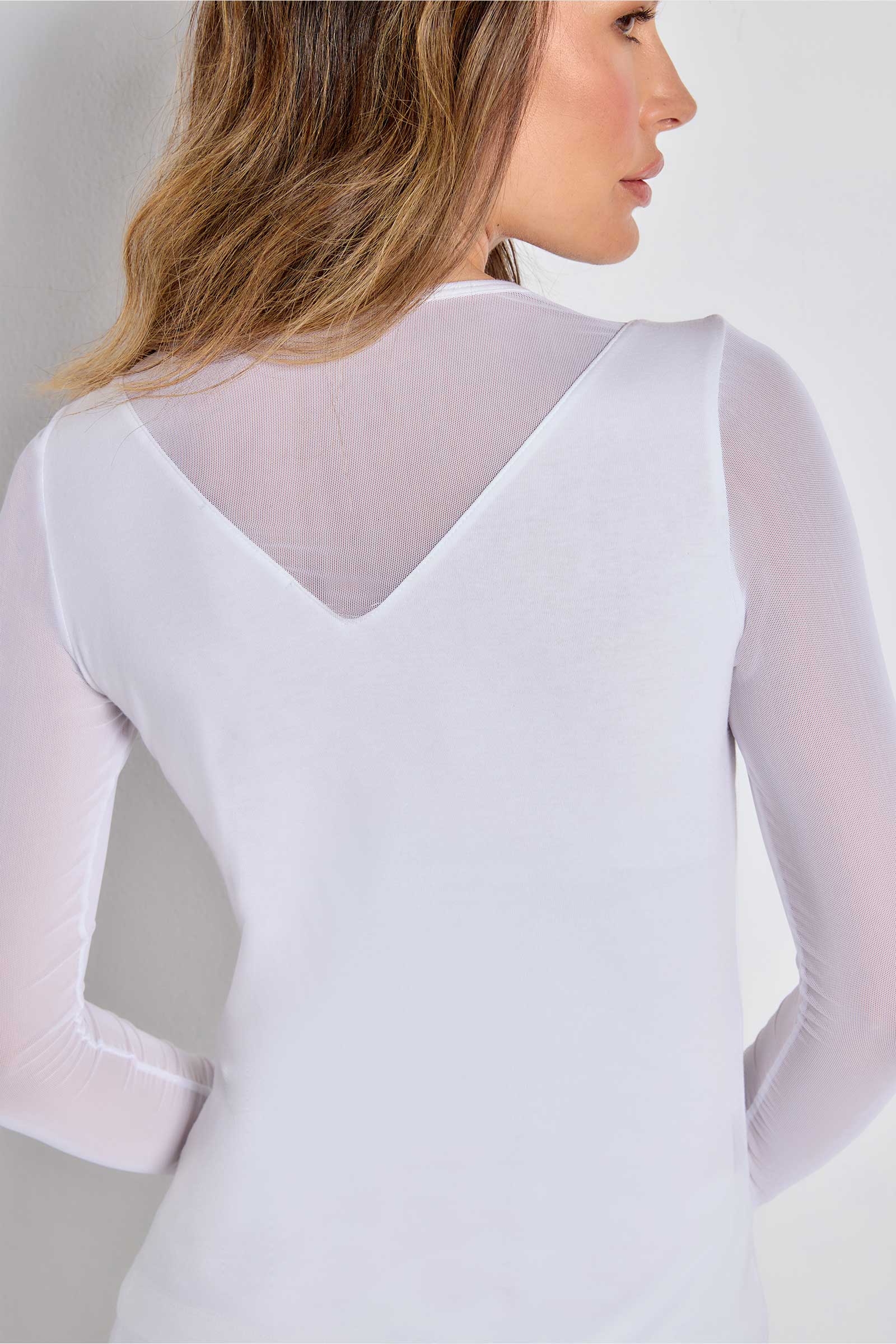 The Best Travel Top. Woman Showing the Back Detail of a Kim Mesh-Sleeve Top in Pima Modal in White.