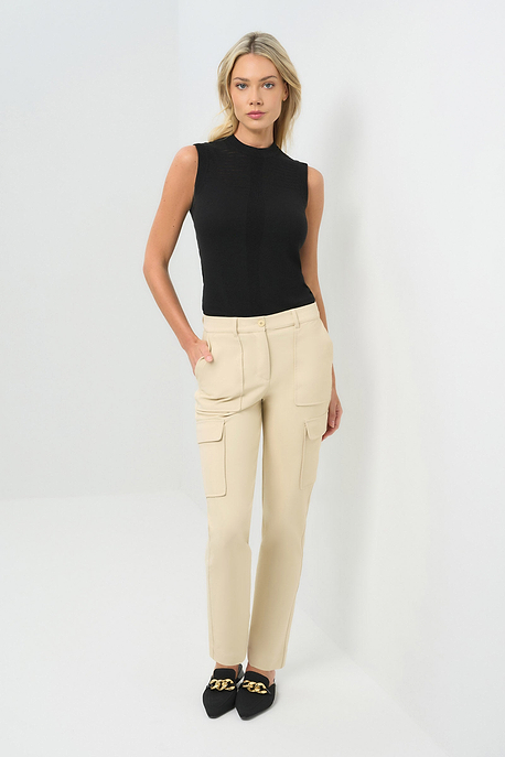 Cream-colored slim-fit cargo pants paired with a black sleeveless mock-neck knit top