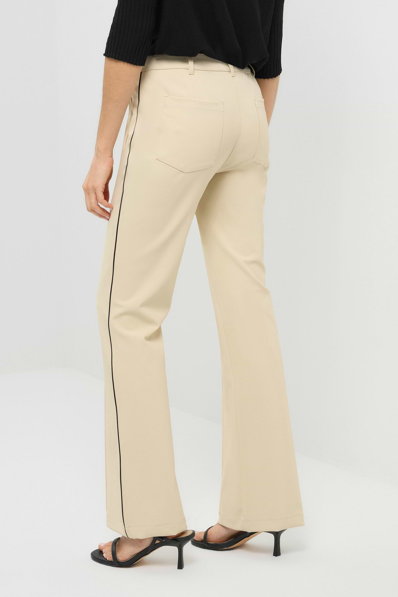 Back view of wheat pants with a black stripe on the side and a pocket.
