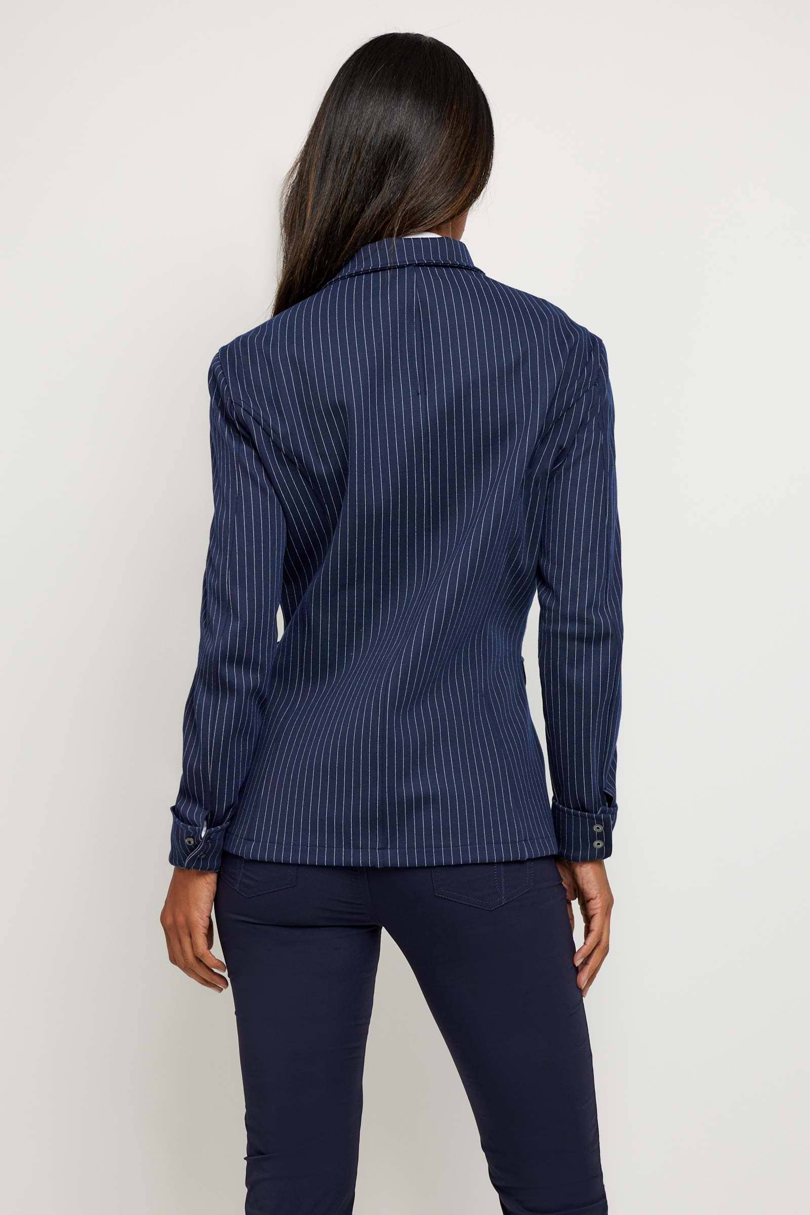 The Best Travel Jacket. Woman Showing the Back Profile of a Lucia Jacket in Navy/White.