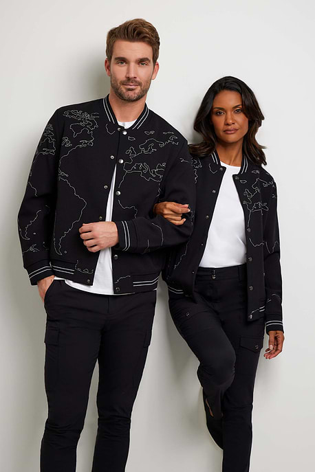 The Best Travel Jacket. Man and Woman Showing the Front Profile of a Map Bomber Jacket in Black.