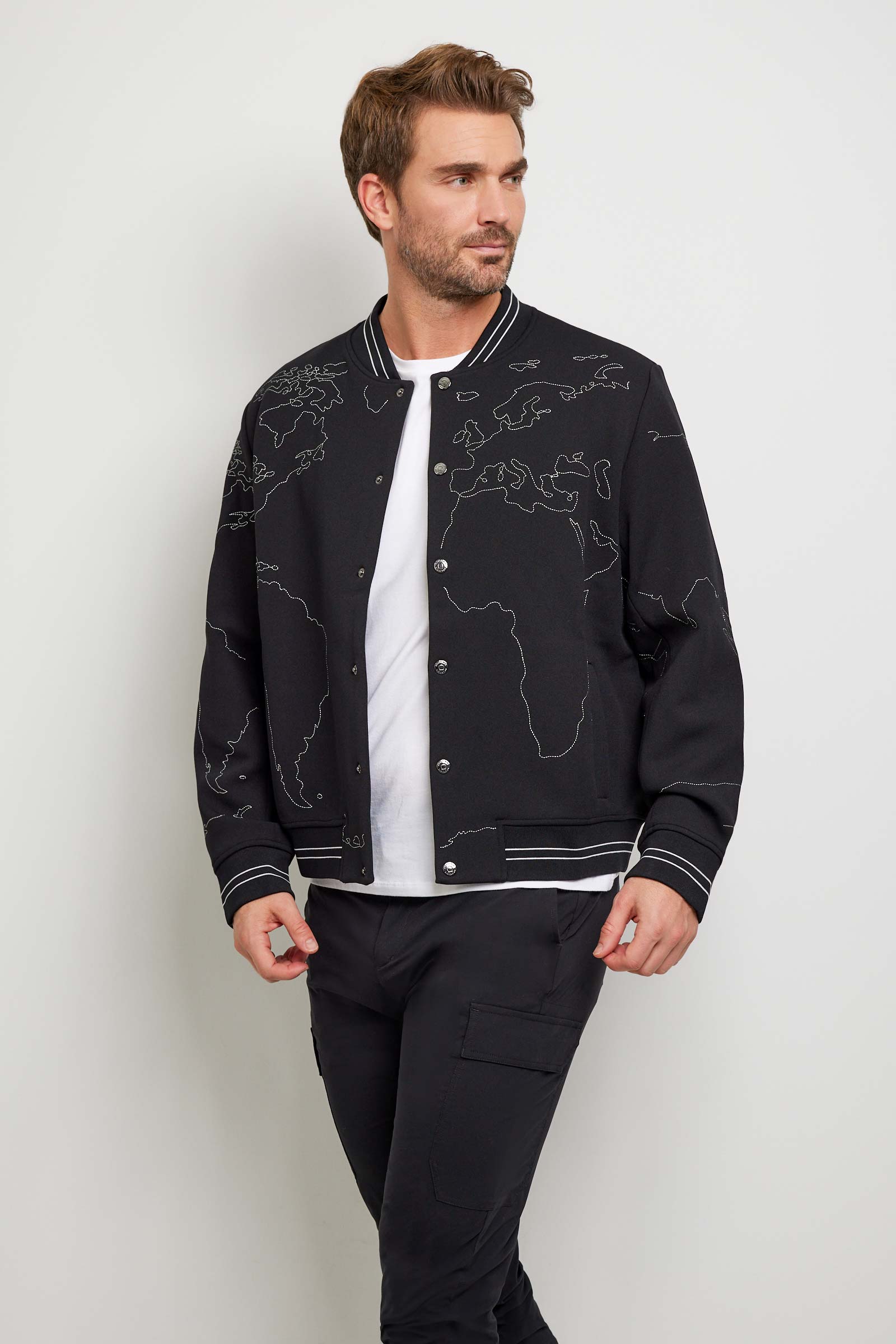 The Best Travel Jacket. Man Showing the Front Profile of a Map Bomber Jacket in Black.