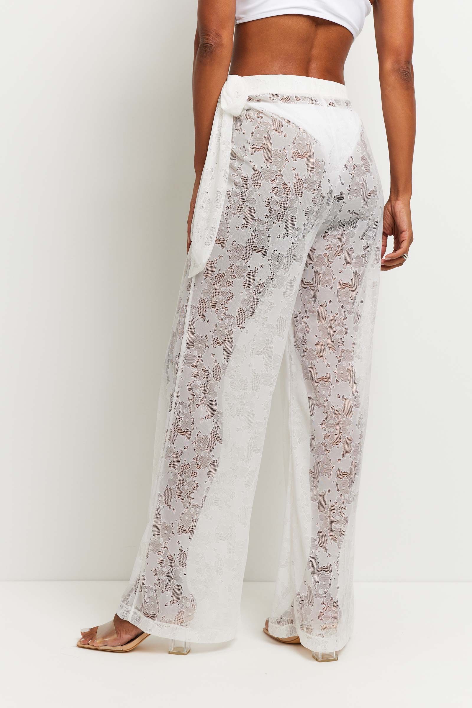 The Best Travel Pants. Woman Showing the Back Profile of a Moana Camo Mesh Pant in White.