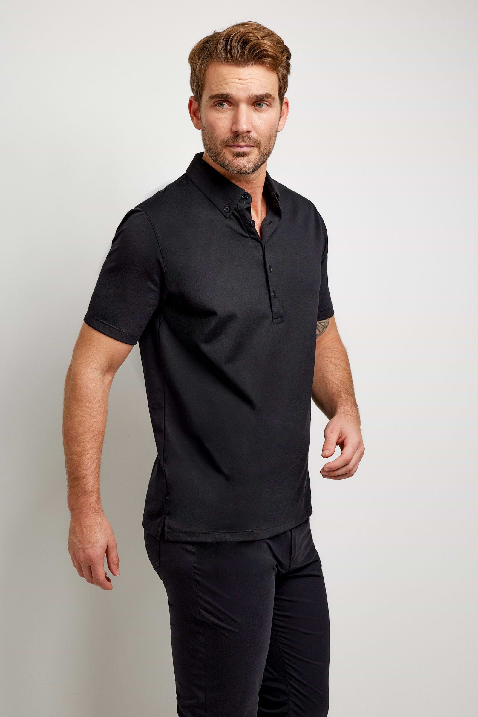 The Best Travel Top. Man Showing the Side Profile of a Men's Ryan Polo in Black.