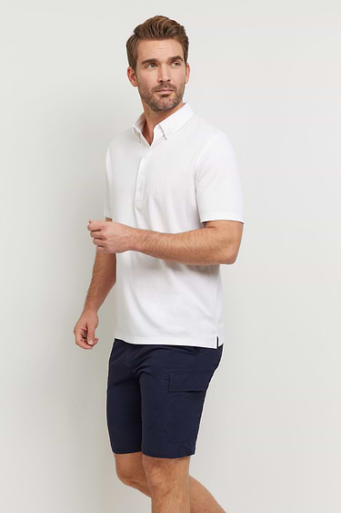 The Best Travel Top. Man Showing the Side Profile of a Men's Ryan Polo in White.