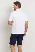 The Best Travel Top. Man Showing the Back Profile of a Men's Ryan Polo in White.