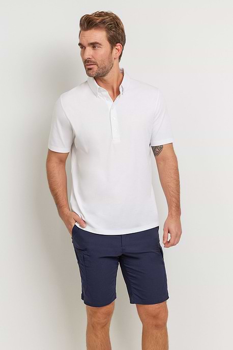 The Best Travel Top. Man Showing the Front Profile of a Men's Ryan Polo in White.