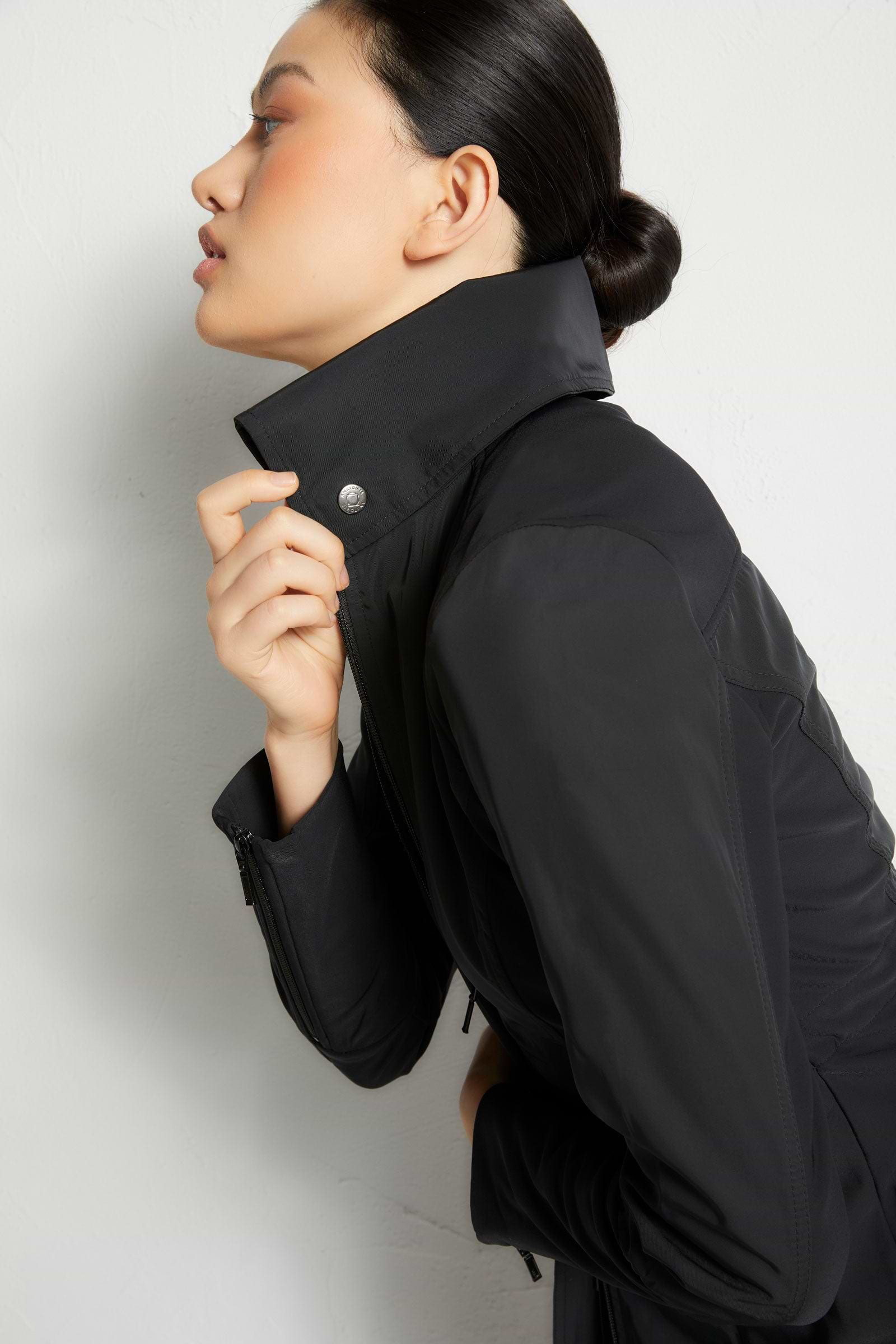 The Best Travel Jacket. Woman Showing the Side Profile of a Travel City Slick Jacket in Black