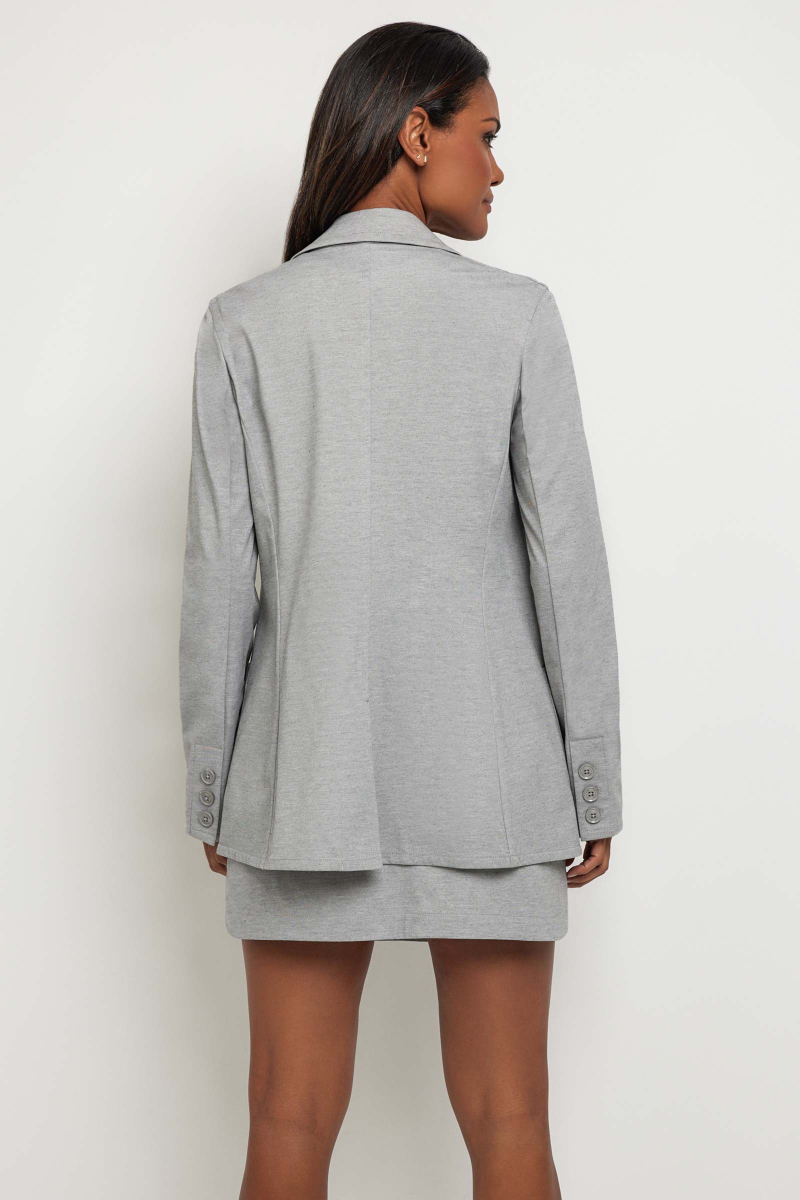 The Best Travel Jacket. Woman Showing the Back Profile of a Vanessa Blazer in Light Heather Grey.