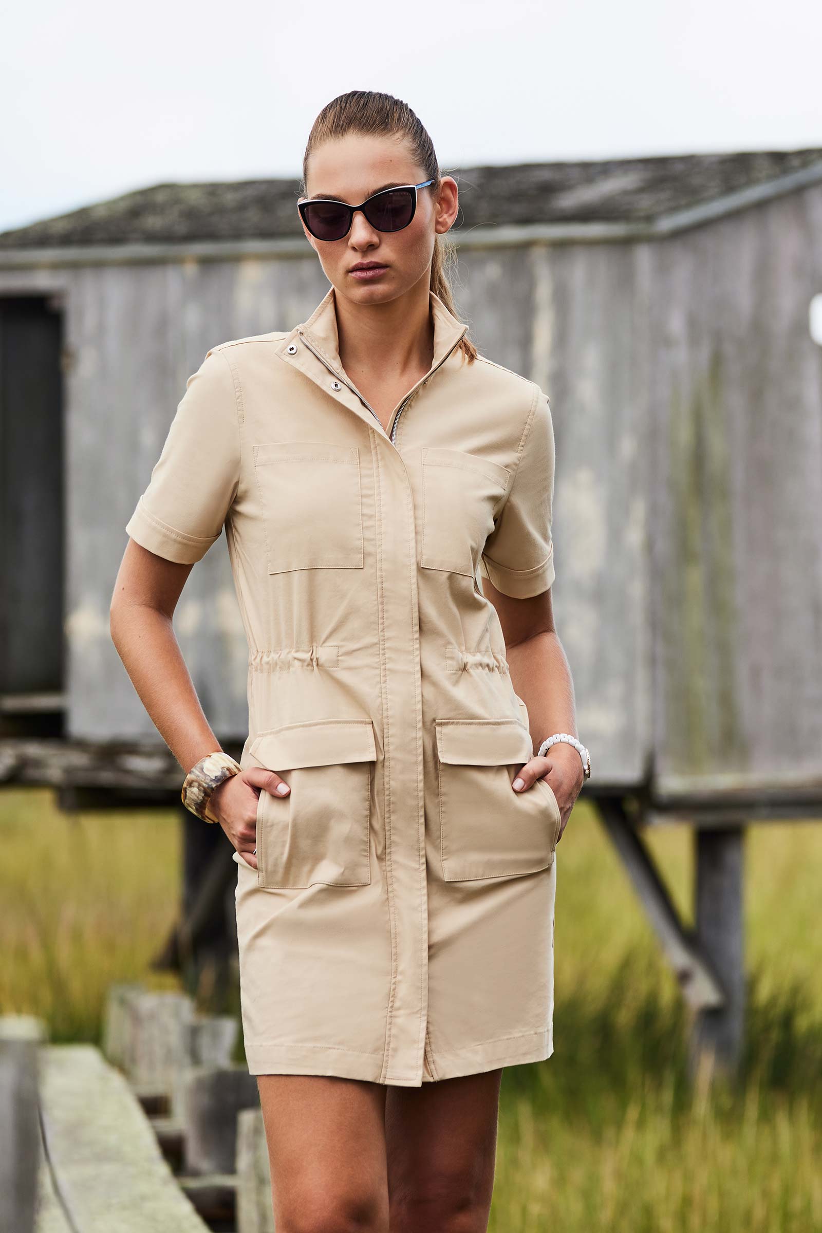 The Best Travel Dress. Lifestyle Image of Woman Showing the Front Profile of a Vivi Dress in Cocoa Sand.