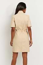 The Best Travel Dress. Woman Showing the Back Profile of a Vivi Dress in Cocoa Sand.