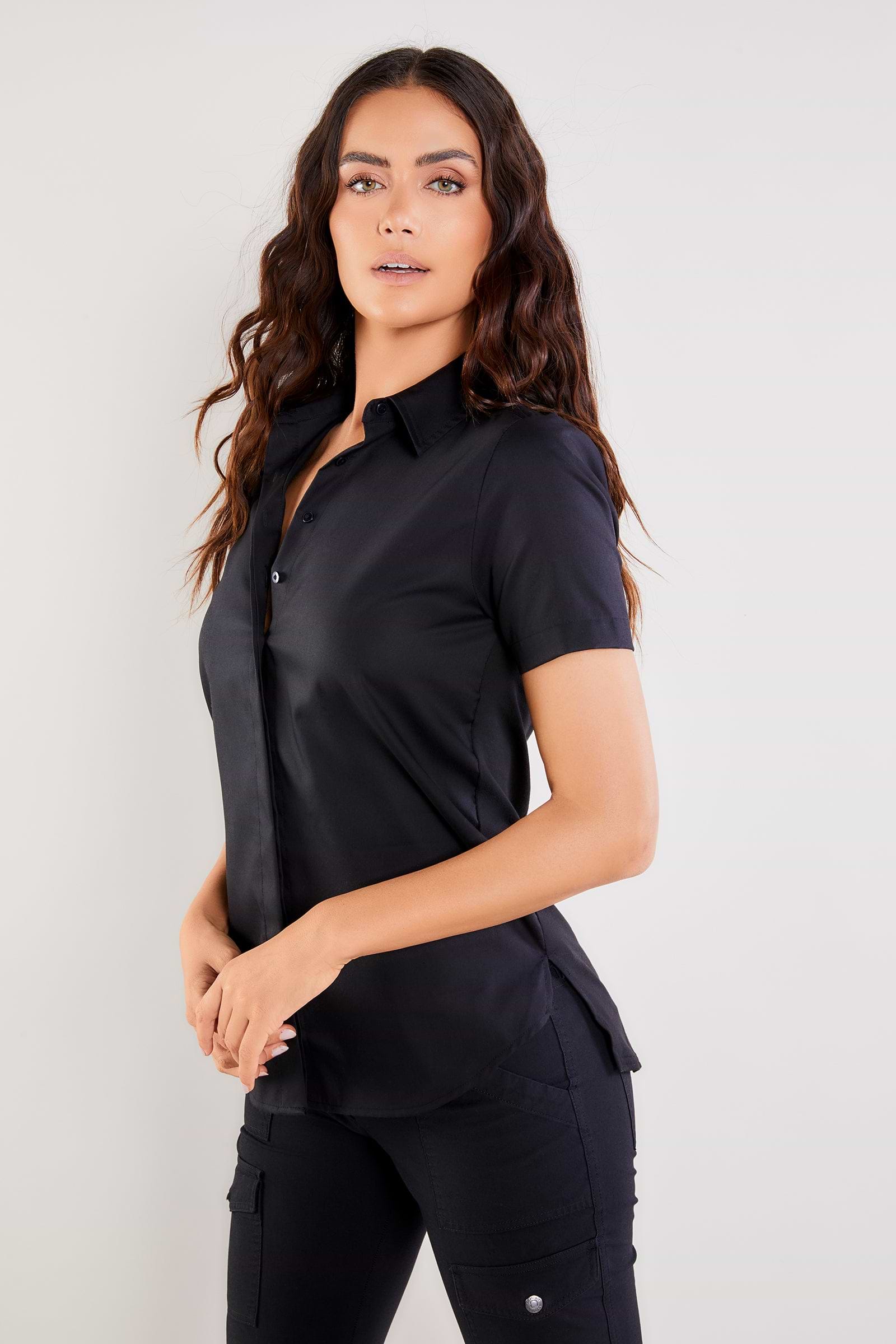 The Best Travel Top. Woman Showing the Side Profile of a Helia Top in Black.