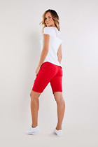 The Best Travel Shorts. Woman Showing the Back Profile of an Apiedi Shorts in Atomic Red.