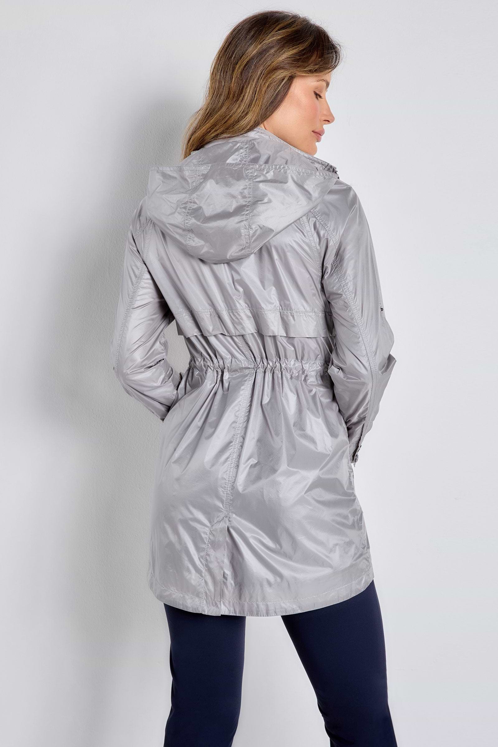 The Best Travel Jacket. Woman Showing the Back Profile of a Ramona Windbreaker Jacket in Silver Grey.