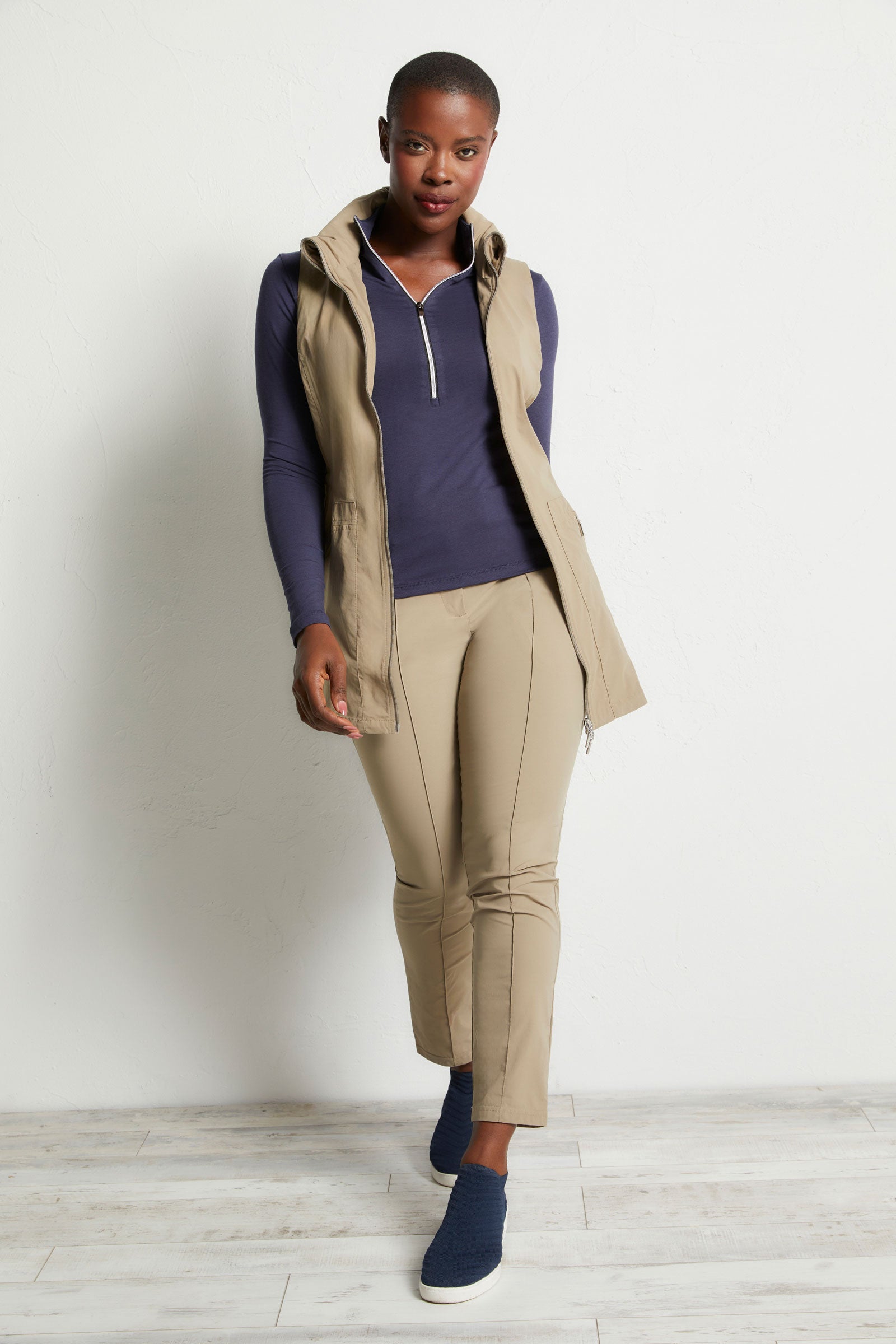 The Best Travel Vest. Woman Showing the Front Profile of a Delaney Travel Vest in Khaki.